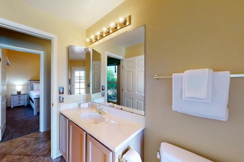 a bathroom with a sink and a large mirror at Hacienda Rancho Vistoso in Oro Valley