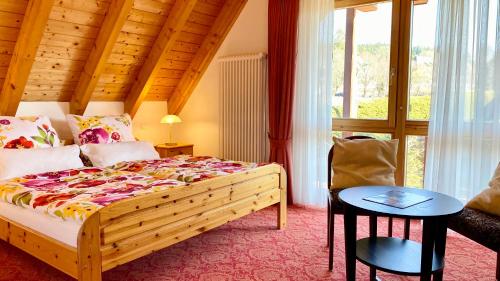 a bedroom with a bed and a table and a window at 4-Star Holiday House Rösslewiese in Hinterzarten