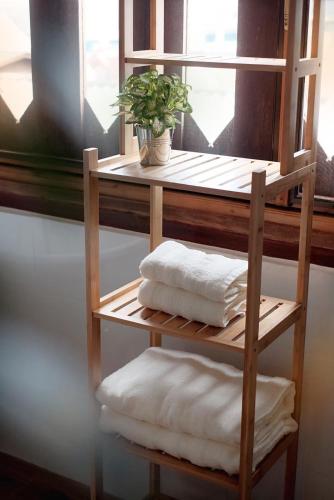 a shelf with towels and a plant in a window at EnVieng House(อองเวียงเฮ้าส์): CM old city, Wat Phrasing in Chiang Mai