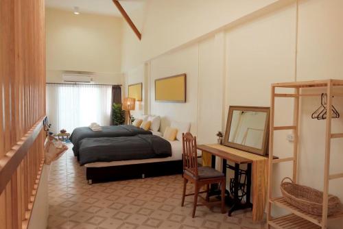 Un dormitorio con una cama, un escritorio y un espejo. en EnVieng House(อองเวียงเฮ้าส์): CM old city, Wat Phrasing, en Chiang Mai