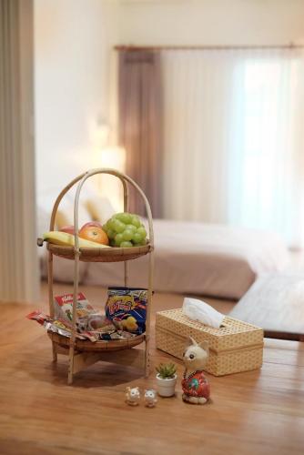 a shelf with a basket of fruit on a table at EnVieng House(อองเวียงเฮ้าส์): CM old city, Wat Phrasing in Chiang Mai