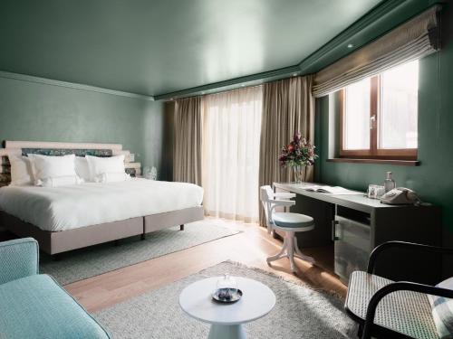 a hotel room with a bed and a desk at BEAUSiTE Zermatt in Zermatt