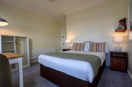 a bedroom with a bed and a table and a desk at The Waterfront in Dingle
