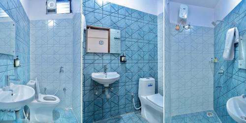 a blue tiled bathroom with a sink and a toilet at Sukoon Pearl inn in Jabalpur