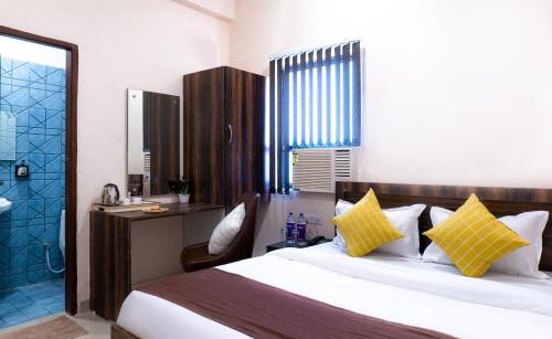 a bedroom with a large bed and a bathroom at Sukoon Pearl inn in Jabalpur