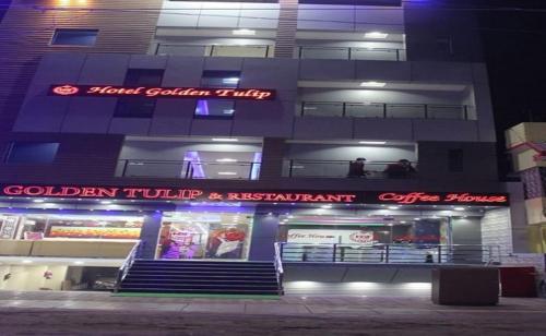 a building with a food court in front at night at HOTEL GOLDEN TULIP in Pūrnia