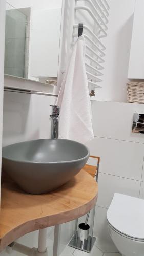 a bathroom with a bowl sink on a wooden table at Apartament Prima in Lubniewice