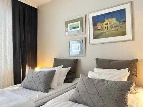 2 camas en una habitación de hotel con pinturas en la pared en Time Apartments Kärpänkuja, en Jyväskylä