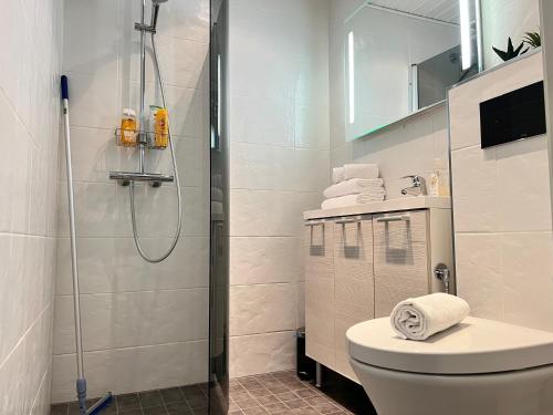 uma casa de banho branca com um chuveiro e um WC. em Time Apartments Kärpänkuja em Jyväskylä