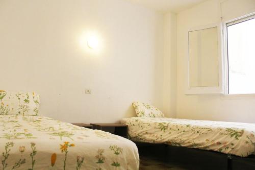 1 dormitorio con 2 camas y ventana en Lloret Centre Apartment, en Lloret de Mar