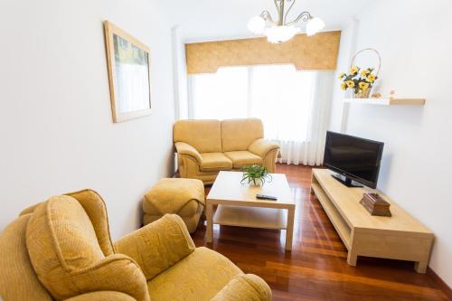 a living room with two chairs and a tv at Casa Goros II in Melide