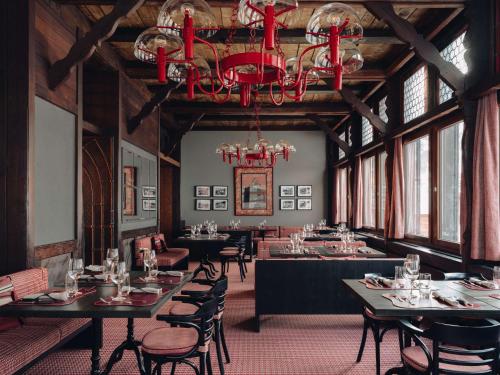 een eetkamer met tafels en stoelen en een kroonluchter bij BEAUSiTE Zermatt in Zermatt