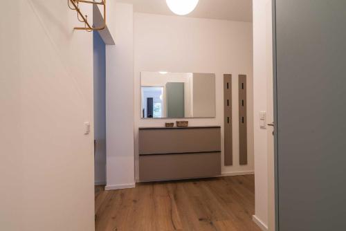 a bathroom with a sink and a mirror on a wall at Wave1 in Norderney