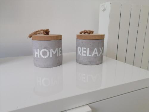 two trash cans sitting on a table with the words home and relax at Home Beach in Figueira da Foz