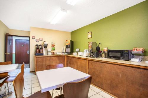 a restaurant with a counter and a table and chairs at Super 8 by Wyndham Craig in Craig