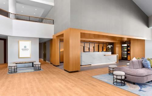 a living room with a couch and a table at Sonesta Silicon Valley in Milpitas