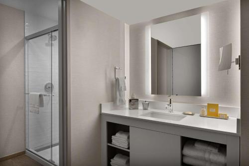 a white bathroom with a sink and a mirror at Sonesta Silicon Valley in Milpitas
