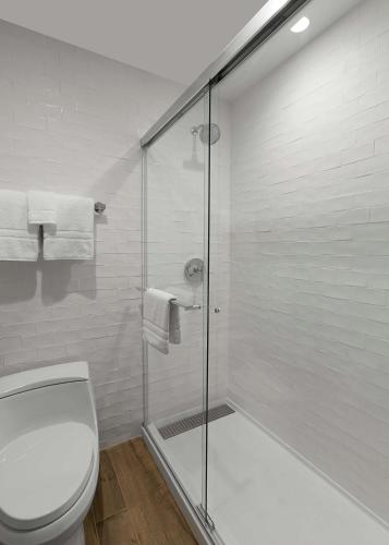 a bathroom with a toilet and a glass shower at Sonesta Silicon Valley in Milpitas