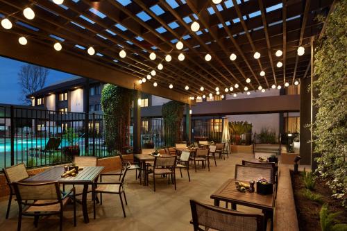 an outdoor patio with tables and chairs and lights at Sonesta Silicon Valley in Milpitas
