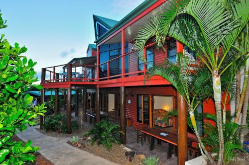 a large house with a palm tree in front of it at Escape 1770 Motel - No Kids - NO SMOKING - No Partying in Agnes Water