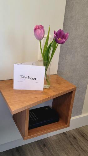 a table with a vase with flowers and a box at Tulip Inn Frankfurt Airport in Neu Isenburg