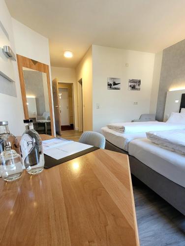 a hotel room with a wooden table and two beds at Tulip Inn Frankfurt Airport in Neu Isenburg