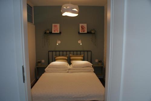 Schlafzimmer mit einem Bett mit weißer Bettwäsche und Kissen in der Unterkunft APARTAMENT CENTRUM OLSZTYNA 2 in Olsztyn