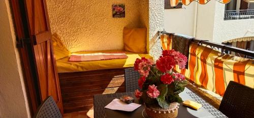 une table avec un vase de fleurs sur un balcon dans l'établissement vacances à la plage, à Saint-Cyr-sur-Mer