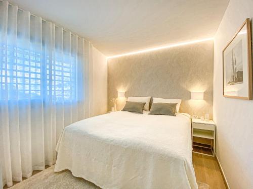 una camera bianca con un letto e una finestra di AMAZING SEA VIEWS - The Wave, Brand new apartment a Fuengirola