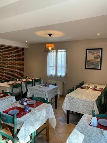 a dining room table with chairs and tables at LOGIS-Auberge Les Vallees Du Perche in Vichères