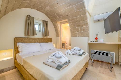 a bedroom with a bed with towels on it at La Torretta Suite - Raro Rooms Collection in Ostuni