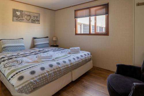 ein Schlafzimmer mit einem großen Bett und einem Fenster in der Unterkunft Drents Genieten - Riegheide met privé jacuzzi in Erm