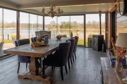 a dining room with a wooden table and chairs at Drents Genieten - Riegheide met privé jacuzzi in Erm