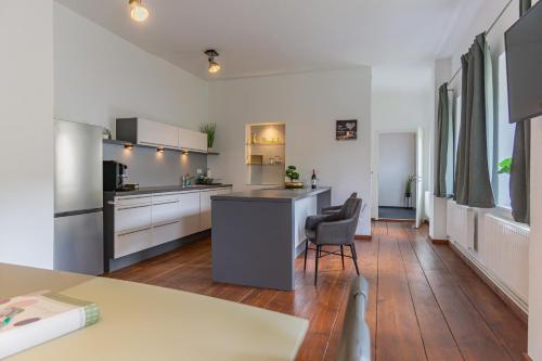 a kitchen with white cabinets and a table and chairs at Exklusive Stadtvilla-190qm- Parkplatz- 3Schlafzimmer- 2 Bäder- Netflix- Waschmaschine- 4 Etagen-nähe Theater in Cottbus