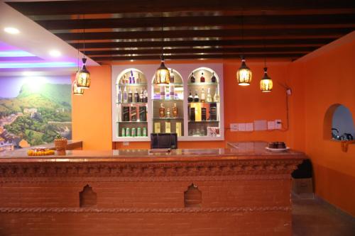 un bar en un restaurante con una pintura en la pared en The Red House Bandipur, en Bandipur