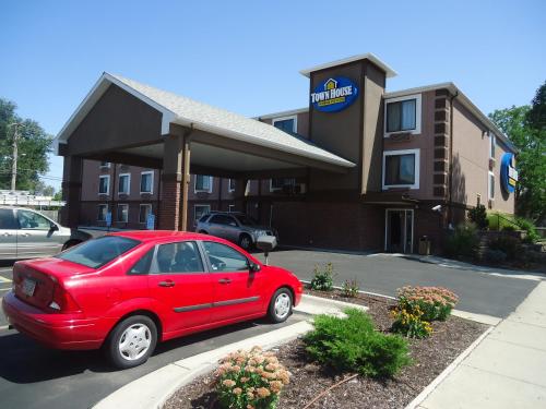 a red car parked in front of a hotel at TownHouse Extended Stay Hotel Downtown in Lincoln