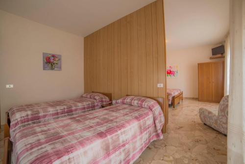 a hotel room with two beds and a tv at Hotel Santa Maria in Assisi