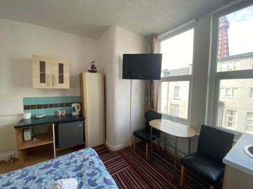 a small room with a bed and a desk and a table at Mellory hotel in Blackpool