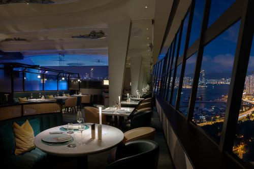 a dining room with a balcony overlooking a city at The Park Lane Hong Kong, a Pullman Hotel in Hong Kong