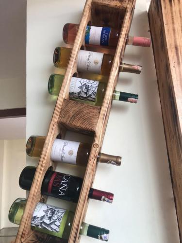 un estante de madera con botellas de vino en Holiday Hostel, en Katmandú