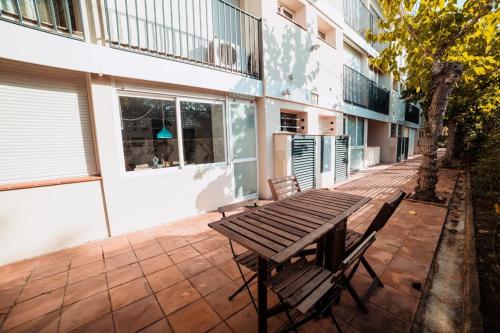 a wooden picnic table sitting on a patio next to a building at Apt con piscina en Calella de Palafrugell, parking gratuito in Calella de Palafrugell