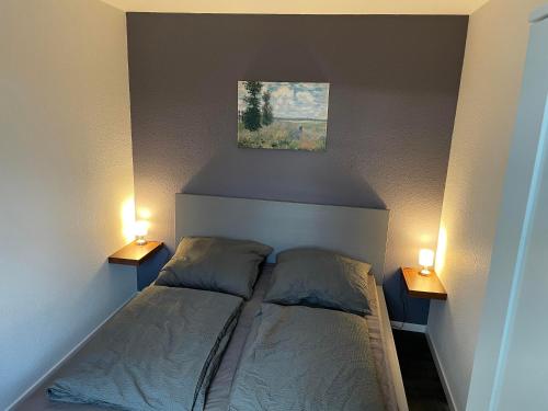 a bedroom with a bed with two lamps on it at Ferienwohnung am West-östlichen Tor in Ecklingerode