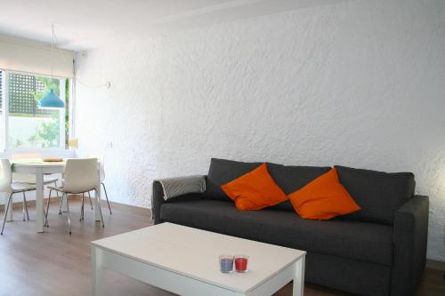 a living room with a couch and a table at Apt con piscina en Calella de Palafrugell, parking gratuito in Calella de Palafrugell