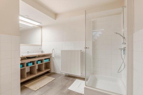 een witte badkamer met een douche en een wastafel bij TOP& ruim duplex woning in PATERSHOL,centrum Gent! in Gent