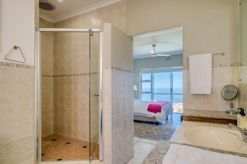 a bathroom with a shower and a tub and a bed at 270 Degrees in Cape Town
