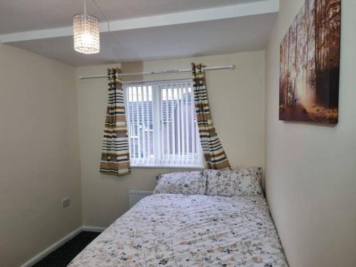 um quarto com uma cama e uma janela em Nice Residential Within Easy Reach To Town em Manchester