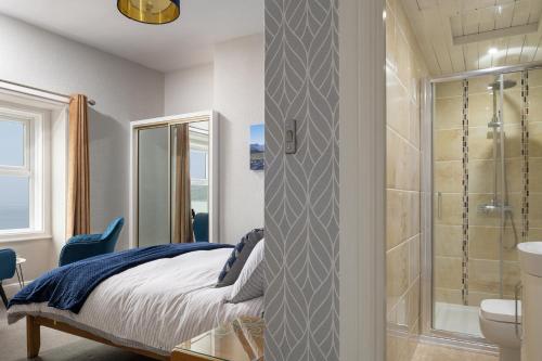 a bedroom with a bed and a bathroom with a shower at The Kendrick Exclusively for adults in Llandudno