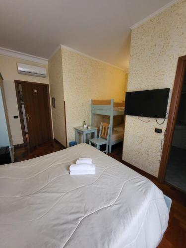 Schlafzimmer mit einem weißen Bett und einem Flachbild-TV in der Unterkunft St. Peter's Rooms Rome in Rom