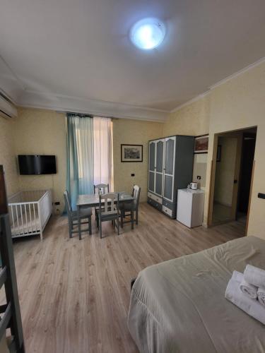 ローマにあるSt. Peter's Rooms Romeのベッド、テーブル、椅子が備わるホテルルームです。