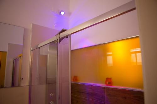 bagno con doccia in vetro con luci viola di B&B Medali a Vernole